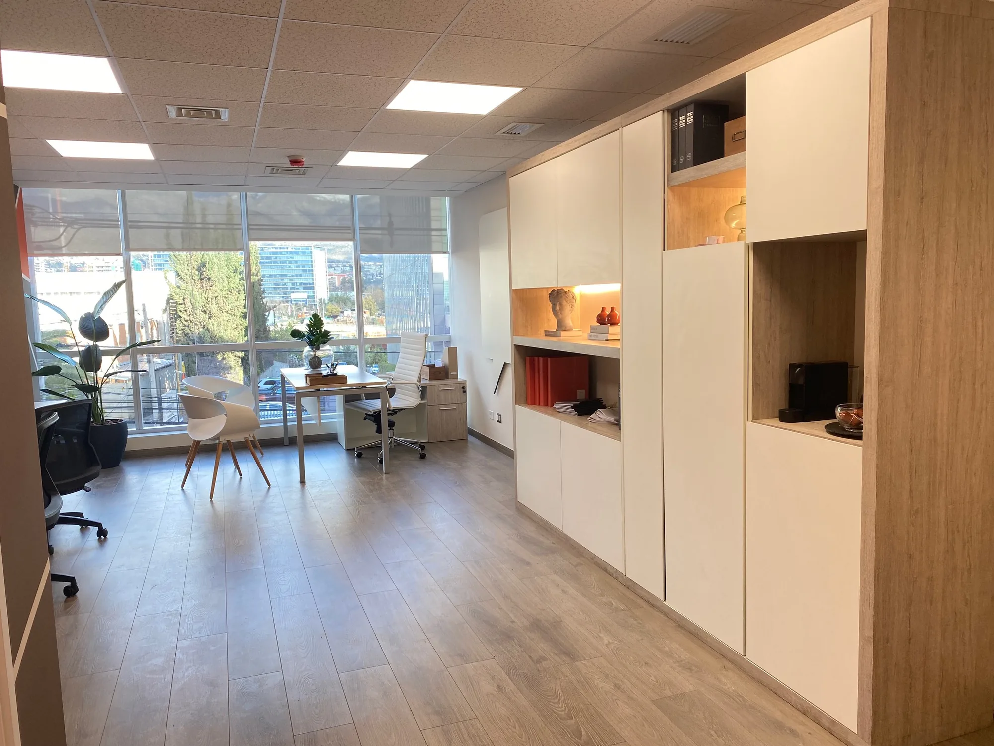 Ambiente de oficina con mesa, sillas y mobiliario de guardado.