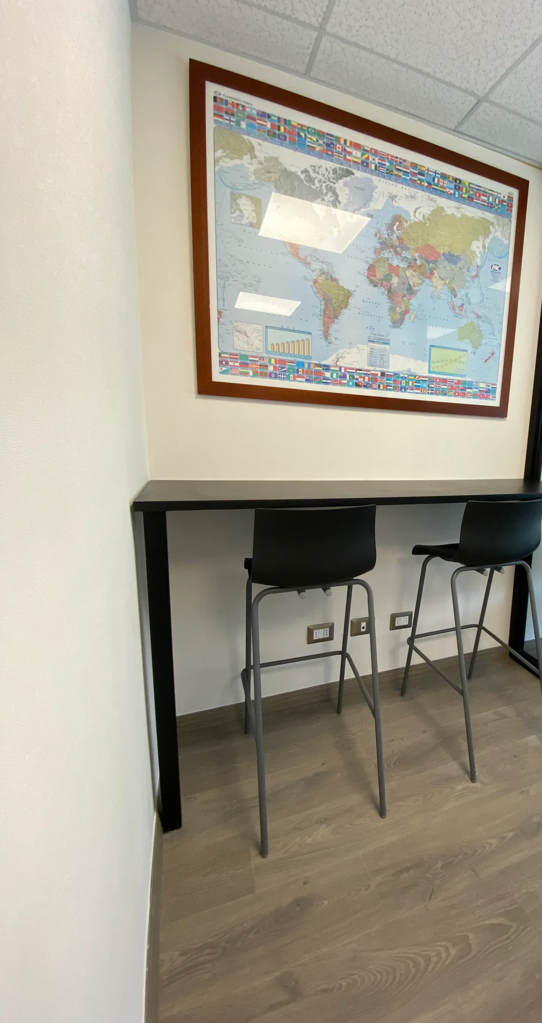 Barra alta con taburetes negros y un mapa decorativo.