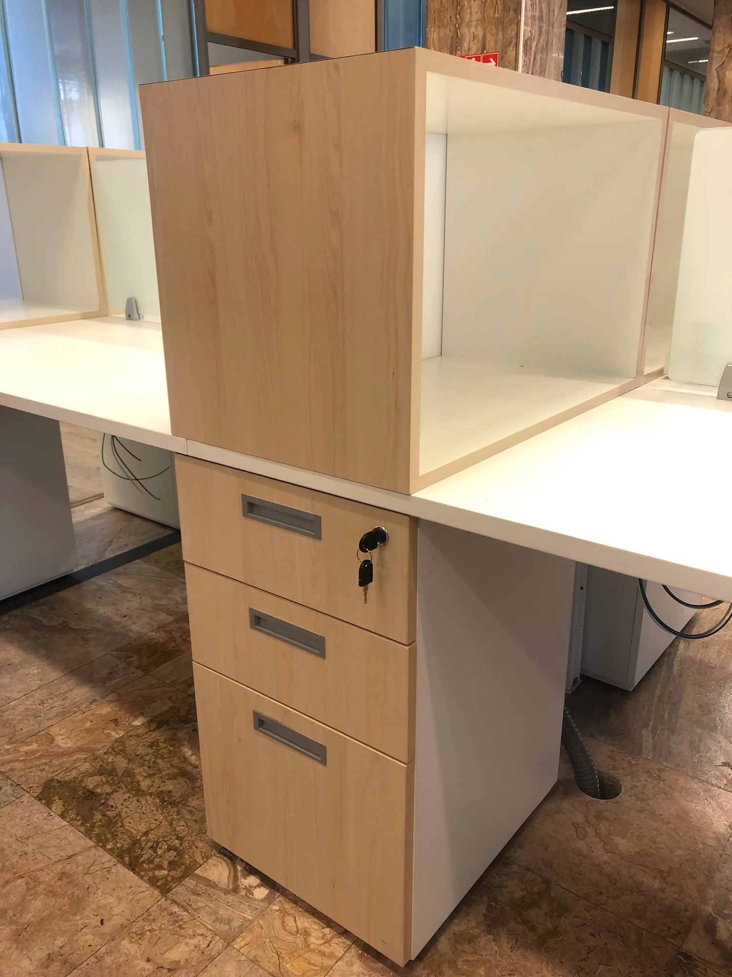 Detalle de escritorio con divisor y cajonera.